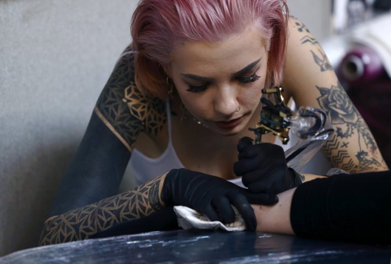 A woman is tattooed at the International London Tattoo Convention in London, Britain September 23, 2016. REUTERS/Neil Hall