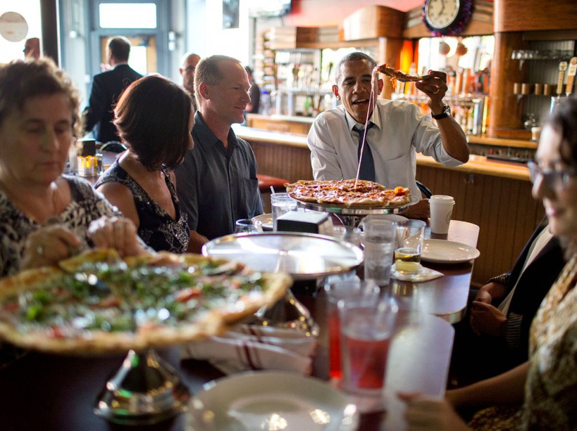 President Barack Obama shares a pizza dinner with individuals who wrote letters to him, at the Wazee Supper Club in Denver, Colo., July 8, 2014. (Official White House Photo by Pete Souza) This official White House photograph is being made available only for publication by news organizations and/or for personal use printing by the subject(s) of the photograph. The photograph may not be manipulated in any way and may not be used in commercial or political materials, advertisements, emails, products, promotions that in any way suggests approval or endorsement of the President, the First Family, or the White House.