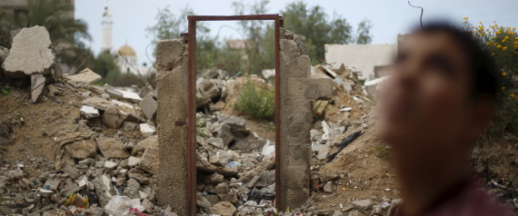 A Palestinian teen stands next to the frame of a destroyed house doorway, on which British street artist Banksy painted an image of a goddess holding her head in her hand, after the door with the painted image was sold in the northern Gaza Strip